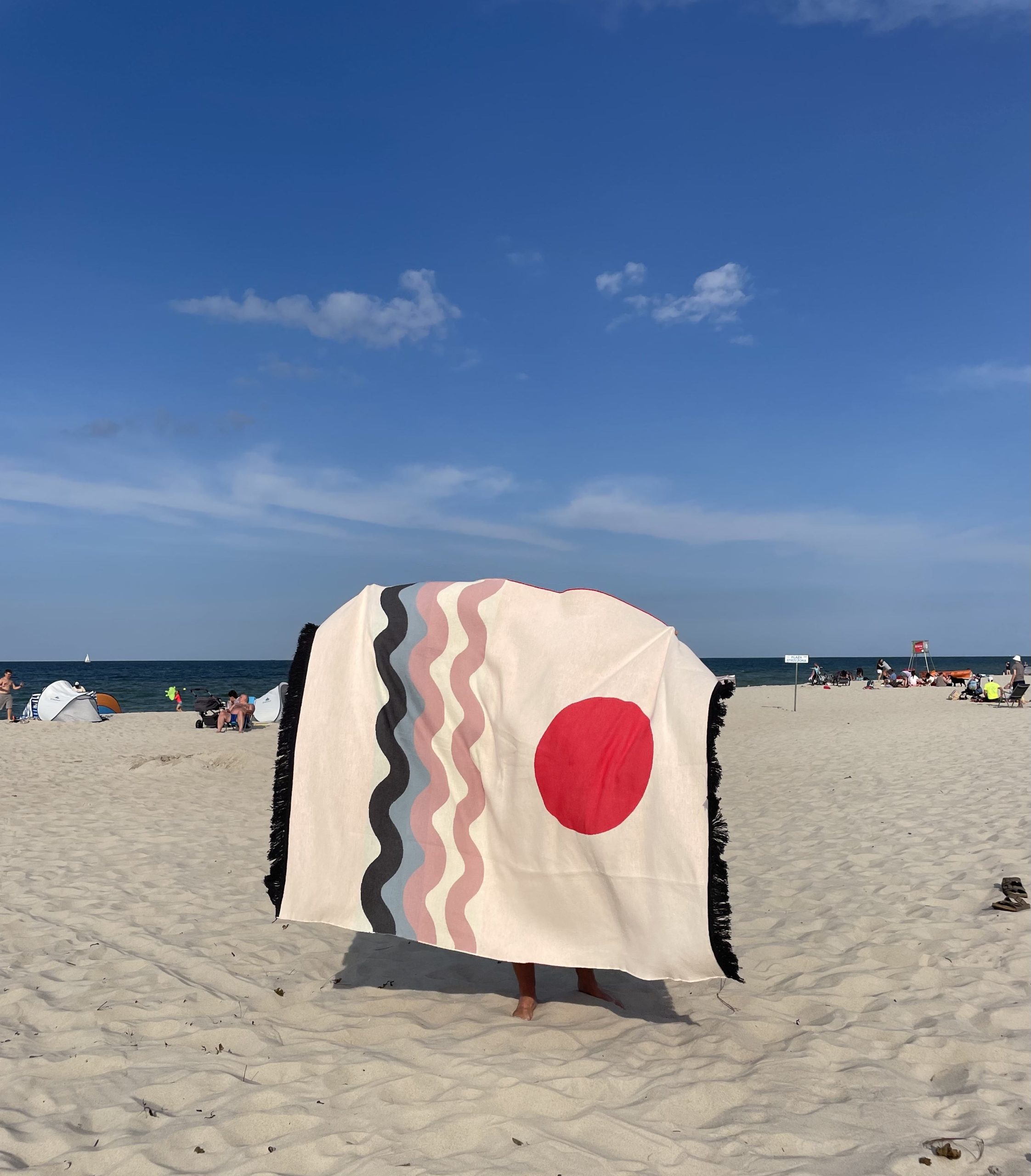 Designerska bawełniana narzuta na łóżko Surfer Baltic Red od Hogai. 165x210 cm – czerwono biały wzór inspirowany Bałtykiem.