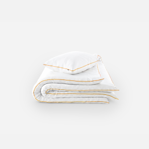 Folded white bedding with orange piping, stacked neatly (duvet and pillow)